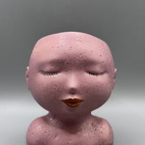 A detailed profile of a feminine face planter with refined features, hand-finished in a metallic rose quartz pink shimmer against a clean grey background.