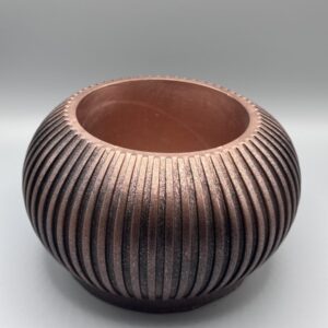Round ribbed copper planter with textured metallic finish and wide opening on neutral background.