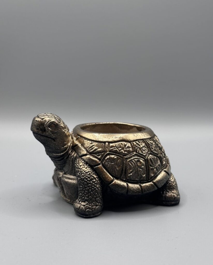 Small decorative tortoise-shaped planter with an antiqued bronze finish and detailed shell carvings, shown against a grey background.