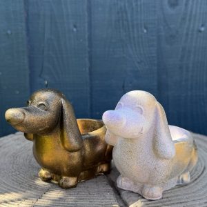 Hand-cast long-eared puppy planter in antique gold, head raised with ears hanging down, on a wooden log